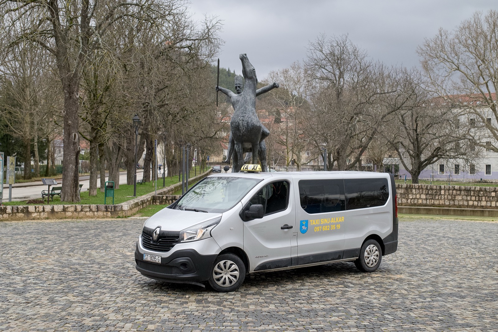 Taxi Sinj Alkar — kombi Renault Trafic za 8 putnika ispred spomenika Alkara u Sinju